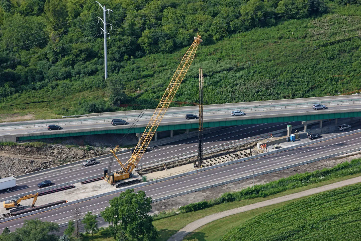 A crane is on the side of a highway.